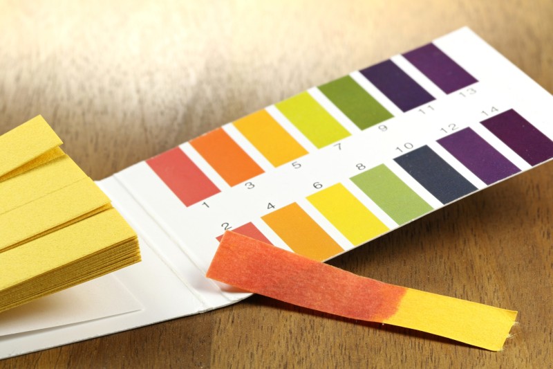 pH value test strips with red discoloration