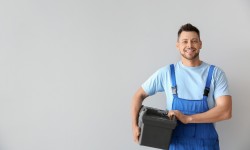 Portrait of handsome plumber with tools box on white background