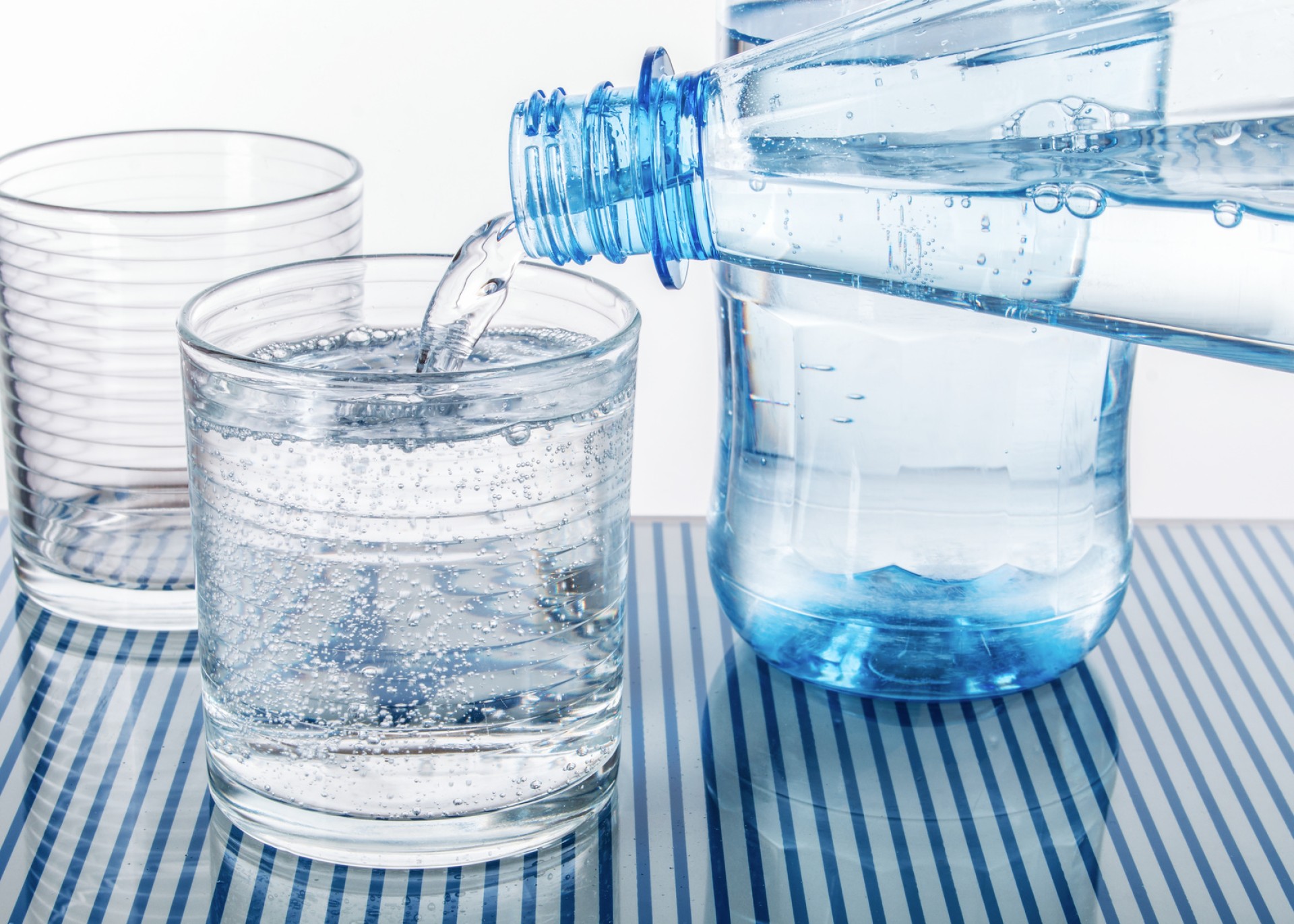 Two glasses are filled with different water to illustrate the different water treatment requirements