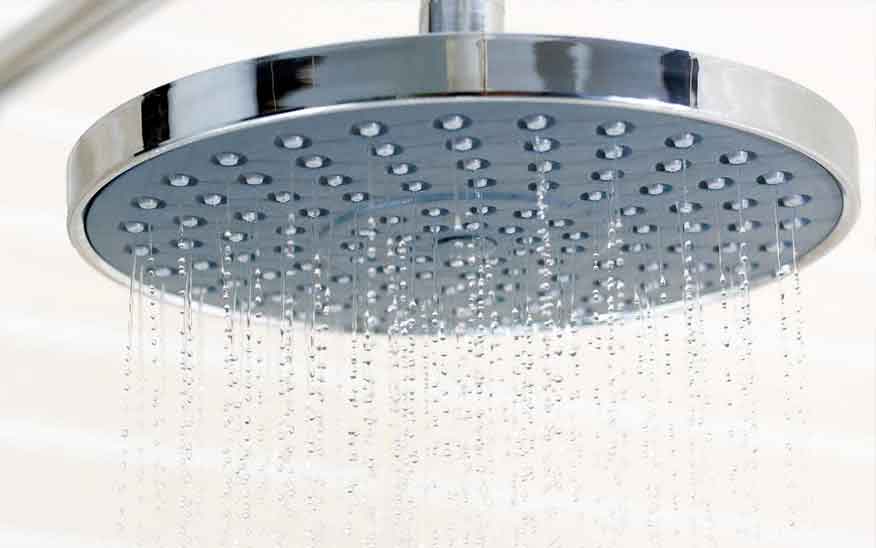 Softened water flows from a shower head, which was treated using a water treatment system